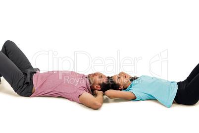 Peaceful young couple laying on floor with hands on their heads