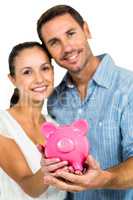 Portrait of couple holding piggybank