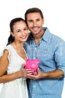 Excited couple holding piggybank