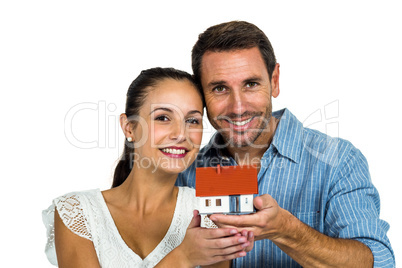 Excited couple holding house model