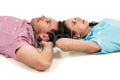 Couple relaxing on floor with hands on their heads