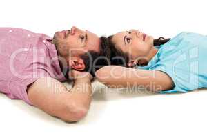 Couple relaxing on floor with hands on their heads