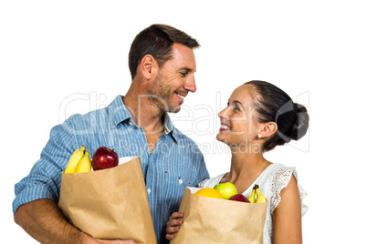 Smiling couple holding grocery bags