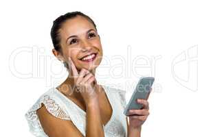 Smiling thoughtful woman holding smartphone