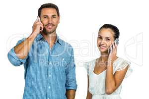 Smiling couple on phone call looking at the camera
