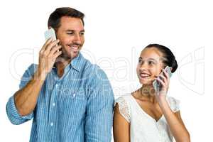 Smiling couple on phone call looking at each other