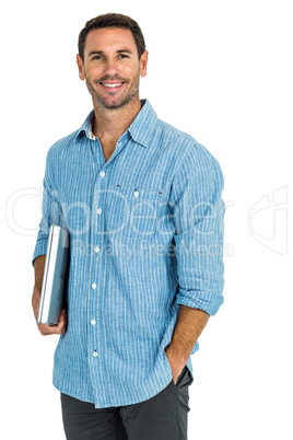 Smiling man holding laptop looking at the camera