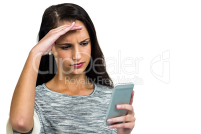 Worried woman with hand on face using smartphone