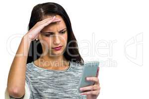 Worried woman with hand on face using smartphone