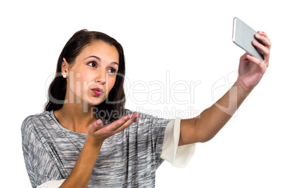Woman blowing kiss while taking selfie