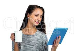 Smiling woman holding cup and tablet