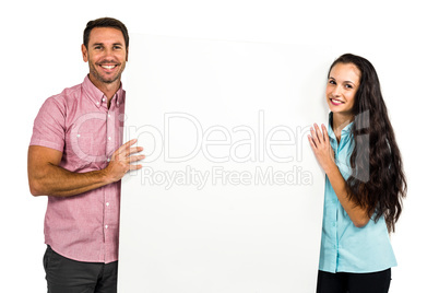 Confident smiling couple holding white sheet