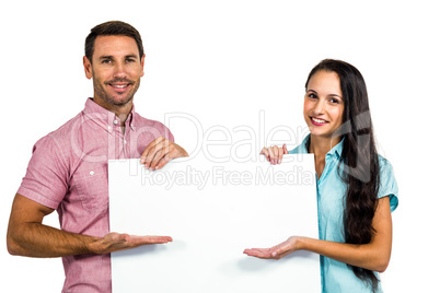 Young happy couple showing blank sheet