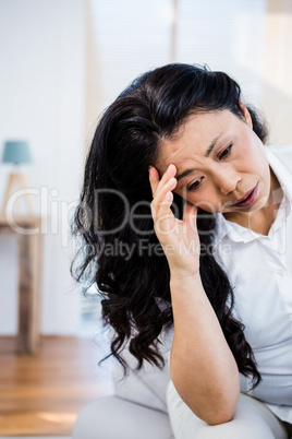 Concerned woman sitting at home