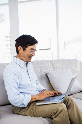 Smiling man at home on couch