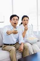 Shocked man and woman at home on couch