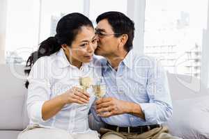 Man kissing woman with glasses of wine