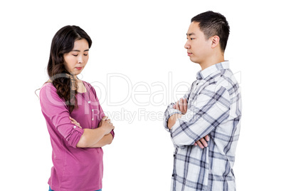 Upset couple standing with arms crossed