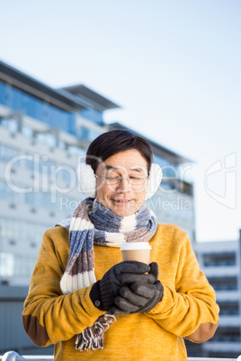 Older asian man with coffee to go