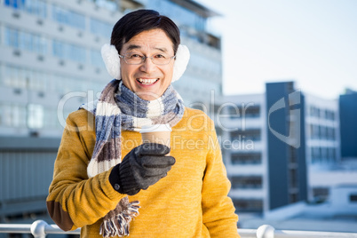 Older asian man with coffee to go