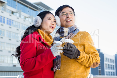 Older asian couple with coffee to go