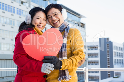 Older asian couple showing a heart
