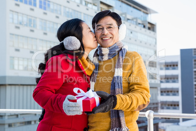 Older asian couple on balcony with gift