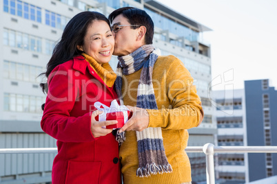 Older asian couple on balcony with gift