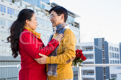 Older asian couple on balcony with gift