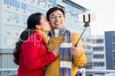 Older asian couple on balcony taking selfie