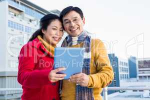 Asian couple on balcony using tablet