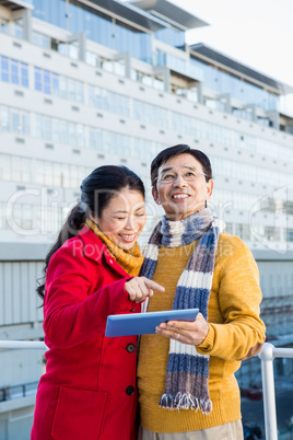 Asian couple on balcony using tablet