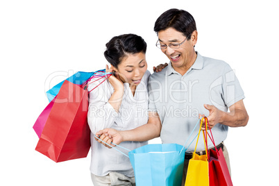 Older asian couple with shopping bags