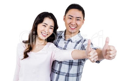 Couple showing thumbs up while standing