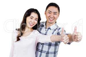 Couple showing thumbs up while standing