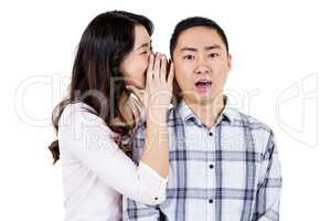 Woman whispering secret to husband