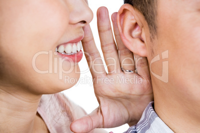 Cropped image of woman whispering secret to husband