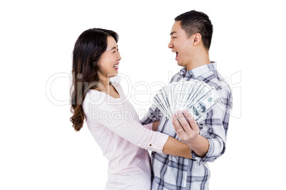 Cheerful happy couple holding money while standing