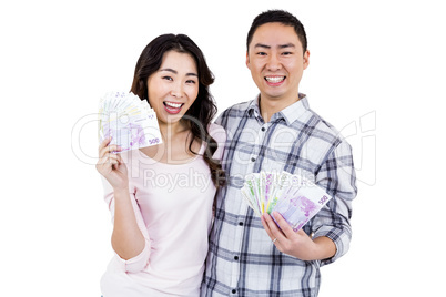 Portrait of happy cheerful couple holding money
