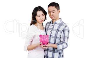 Couple holding their piggy bank