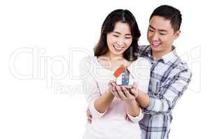 Happy couple holding a model house
