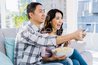 Cheerful young couple sitting on sofa