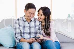 Young happy couple using smart phone