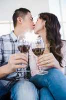 Couple kissing and holding wineglasses