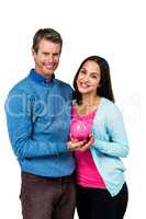Portrait of couple holding piggy bank
