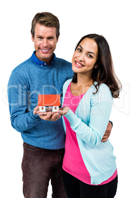 Portrait of couple holding model house