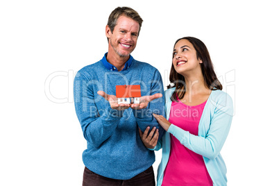 Happy couple holding model house