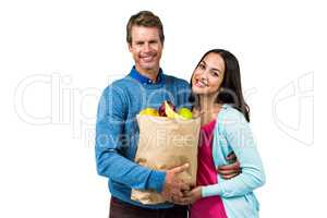 Couple holding bag of fruits