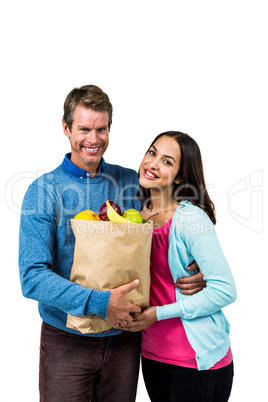 Man and woman holding bag of fruits