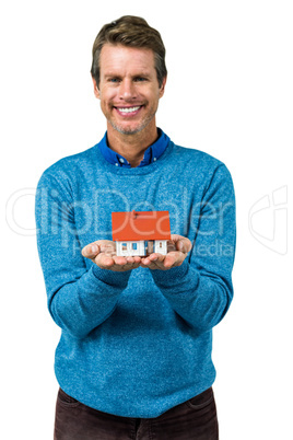 Portrait of smiling man holding model house